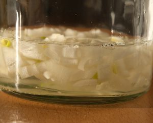 Zwiebelstückchen im Glas mit Essig